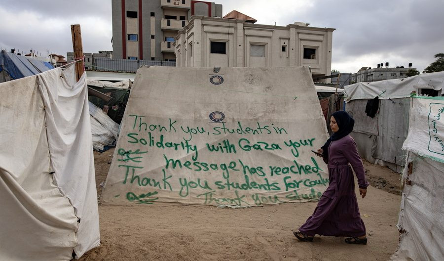 Παλαιστίνια περπατά μπροστά από ένα ευχαριστήριο μήνυμα αφιερωμένο σε φοιτητές του Πανεπιστημίου Κολούμπια, στον προσφυγικό καταυλισμό της Ράφα