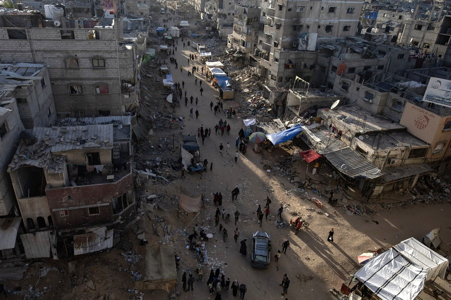 

Παλαιστίνιοι στον καταυλισμό Χαν Γιουνίς δίπλα στα ερείπια των κατεστραμμένων σπιτιών τους, αφού ο ισραηλινός στρατός τους ζήτησε να εκκενώσουν την Ράφα, 15 Μαΐου 2024 (EPA/HAITHAM IMAD)