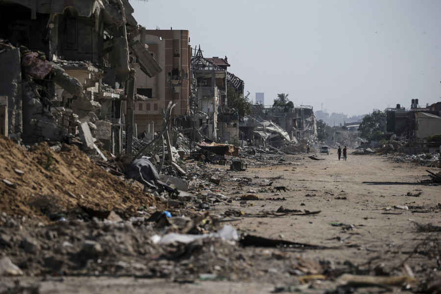 Εσωτερικά εκτοπισμένοι Παλαιστίνιοι περπατούν δίπλα σε κατεστραμμένα κτίρια στο Χαν Γιουνίς, νότια της Λωρίδας της Γάζας