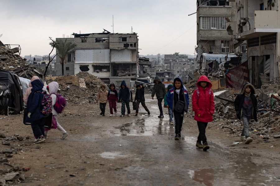 Palestinian children walk past their destroyed homes during heavy rains in Khan Yunis camp in the southern Gaza EPA/HAITHAM IMAD